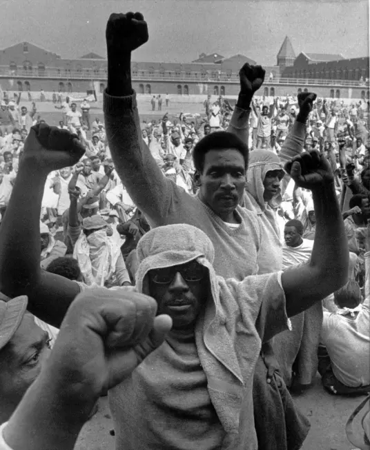 Inmates of Attica state prison in upstate New York raise their fists to show solidarity in their demands during a negotiation session with state prisons Commissioner Russell Oswald, Sept. 10, 1971. AP, [https://nypost.com/2016/08/20/the-true-story-of-the-attica-prison-riot/]